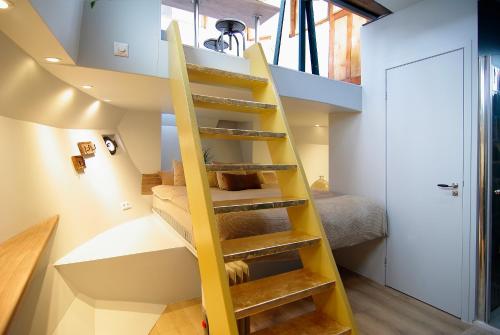 a yellow staircase in a room with a bedroom at Najade Eco Houseboat in Amsterdam