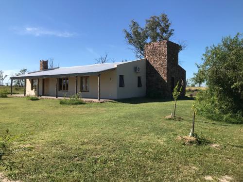 een oud gebouw met een stenen schoorsteen op een erf bij Las yucas in Mercedes