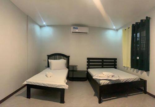 zwei Betten in einem kleinen Zimmer mit zwei Handtüchern darauf in der Unterkunft Lang2 place in Coron