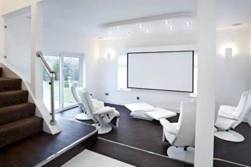 a room with white chairs and a screen at Eastfield Lodge with Hot Tub in Stannington