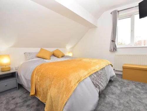 ein weißes Schlafzimmer mit einem Bett mit einer gelben Decke in der Unterkunft Eastfield Lodge with Hot Tub in Stannington