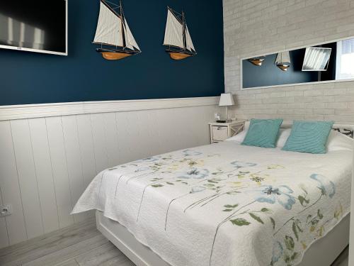 ヤストシェンビャ・グラにあるAmko Style Apartamenty Przystań 26 Willa Nordのベッドルーム1室(青い壁のベッド1台、壁にヨット付)