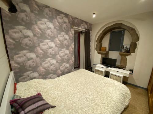 a bedroom with a bed and a wall with clouds at Avélia Bonnevie in Murat
