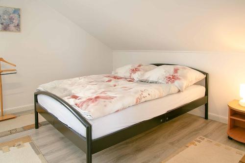 Una cama con flores rosas en una habitación en Ferienwohnung am Feld, en Vettweiß