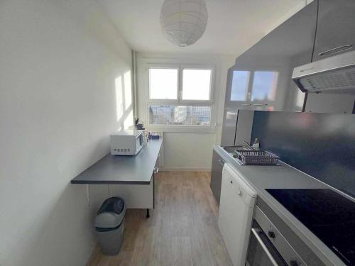 une cuisine avec un comptoir noir dans une pièce dans l'établissement T3 57m2 avec balcon proche gare SNCF, WIFI et café et thé offerts - Balcon, à Orléans