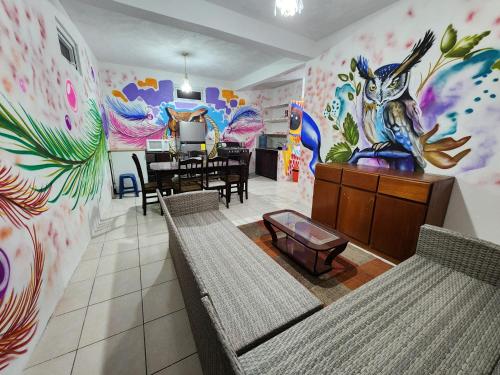 a dining room with a mural of a rabbit on the wall at Casa Búho in Panajachel