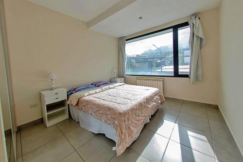 une chambre avec un lit et une grande fenêtre dans l'établissement Patagonia Home - New and spacious, à Ushuaia