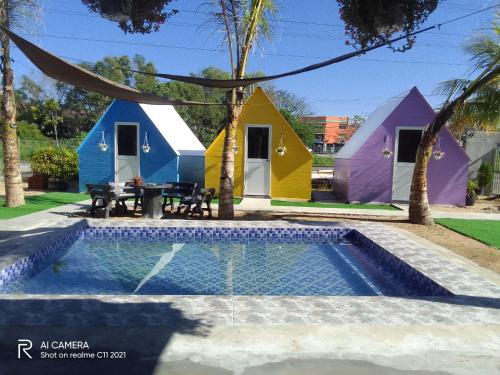un grupo de cabañas coloridas con piscina en IT SWISS GARDEN en Perai