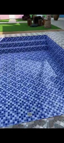 una piscina con azulejos azules en el suelo en IT SWISS GARDEN en Perai