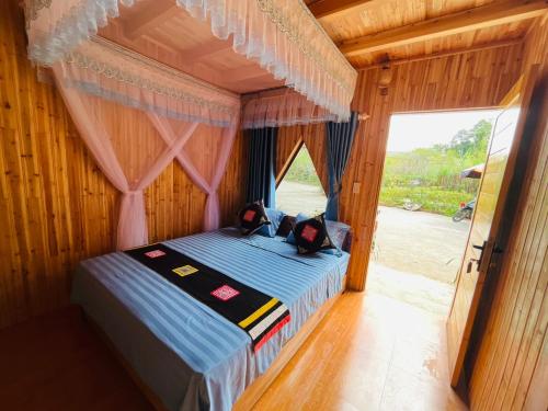 a bedroom with a bed in a room with a window at Pook Homestay in Ha Giang