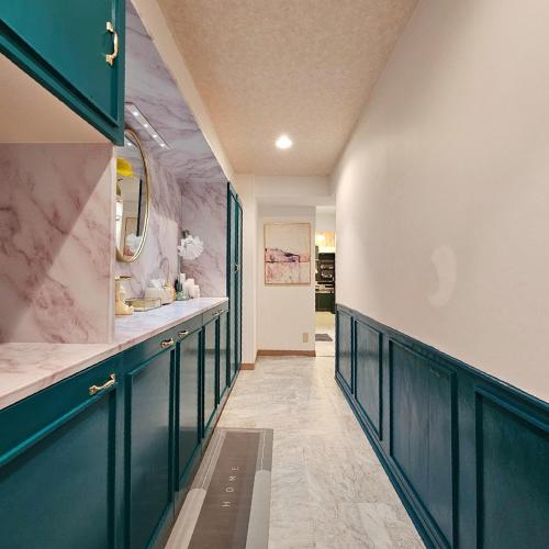 a bathroom with green cabinets and marble counter tops at ueno minowa 502 in Tokyo