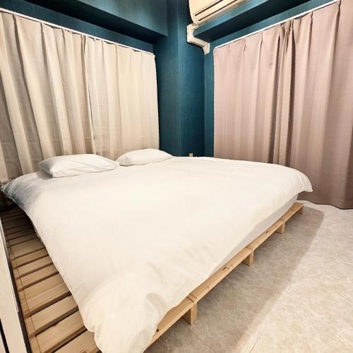 a large bed in a room with curtains at ueno minowa 502 in Tokyo