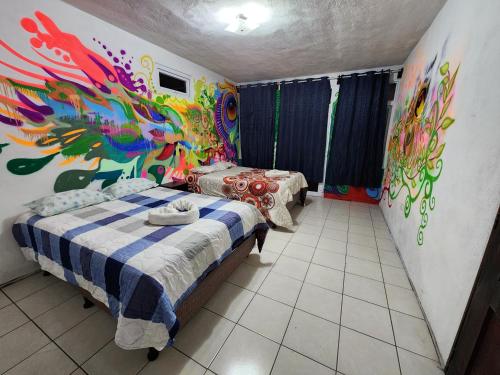 a bedroom with a painting on the wall at Casa Búho in Panajachel