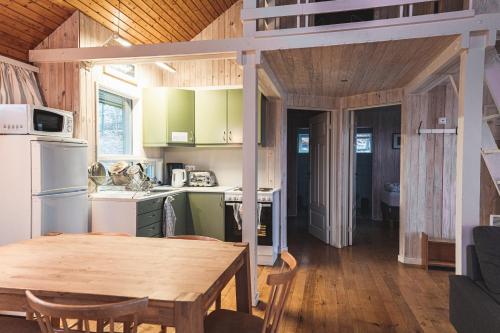 uma cozinha e sala de jantar com uma mesa de madeira em Old Cottages em Höfn