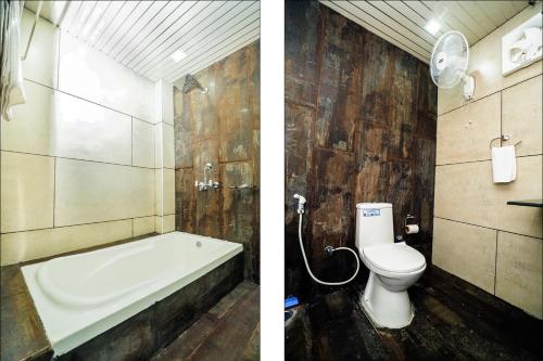 a bathroom with a toilet and a bath tub at The Forest Lake View Resort in Panchkula