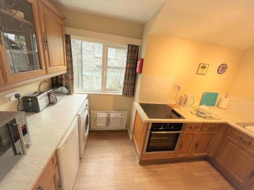 uma pequena cozinha com armários de madeira e um lavatório em 1 Bed in Hawkshead and Tarn Hows LLH13 em Hawkshead