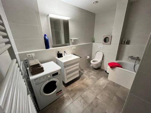 a white bathroom with a sink and a toilet at Luxembourg 2 bedroom apartment in Gasperich in Luxembourg