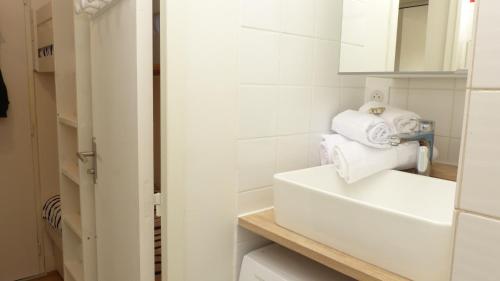 ein weißes Badezimmer mit einem Waschbecken und einem Spiegel in der Unterkunft Studio les pieds dans l’eau à Penthièvre in Saint-Pierre-Quiberon