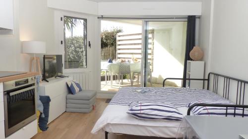 Un dormitorio con una cama y un balcón con una mesa. en Studio les pieds dans l’eau à Penthièvre, en Saint-Pierre-Quiberon