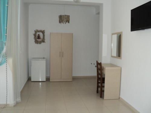 a room with a door and a cabinet and a television at Vila Kosteli in Himare