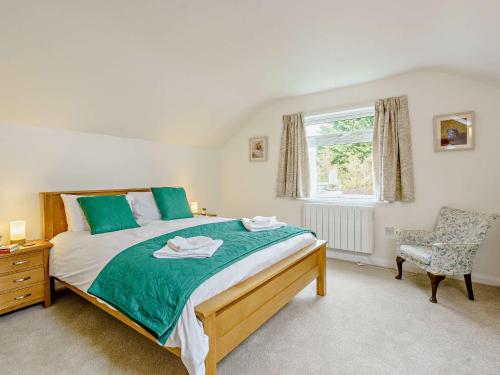 a bedroom with a bed and a chair and a window at 5 Bed in Outgate and Tarn Hows LLH55 in Hawkshead