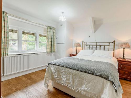 a bedroom with a bed and two lamps and a window at 2 Bed in Glossop 52409 in Glossop