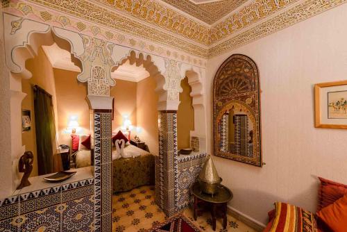 a room with a bed and a large mirror at Abelia Riad - 2024 traveler's Choice Award in Marrakech