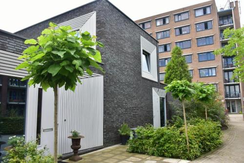 a black brick house with white doors and a tree at B&B Nr 3 in Middelburg