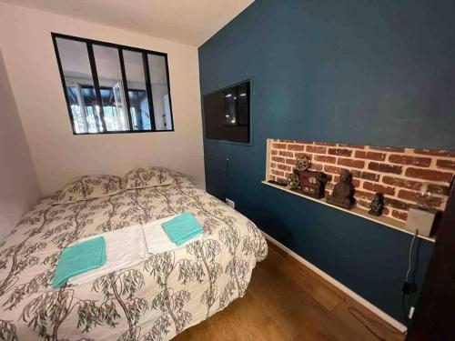 une chambre avec un lit et un mur de briques dans l'établissement Artist Trip, à Paris