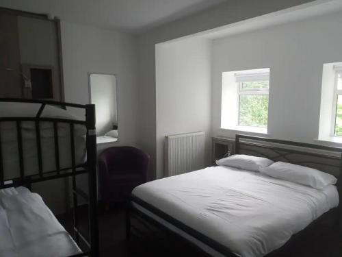 a bedroom with a bed and a chair at DARE VALLEY ACCOMMODATION in Aberdare