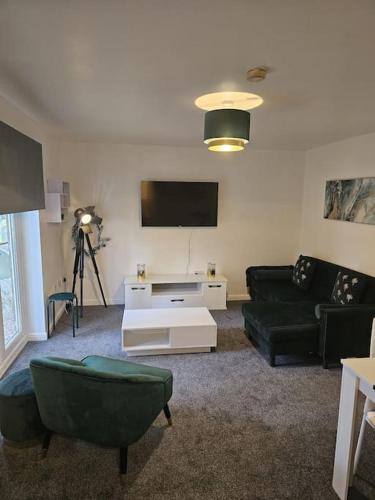 a living room with a couch and a tv at Betjiman Retreat Relaxtion Awaits in Gateshead