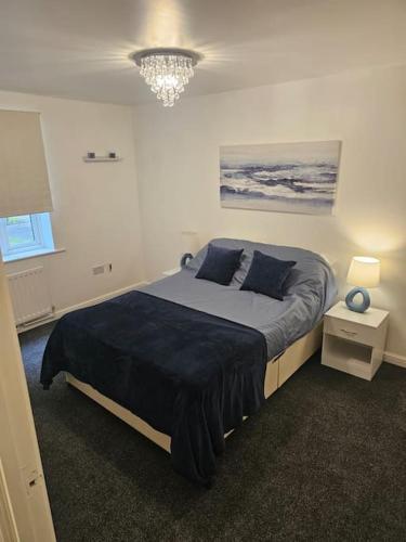 a bedroom with a large bed with blue pillows at Betjiman Retreat Relaxtion Awaits in Gateshead