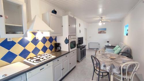 une cuisine avec une table et une salle à manger dans l'établissement Petite Maison des Demoiselles, à Saint-Hilaire-de-Riez