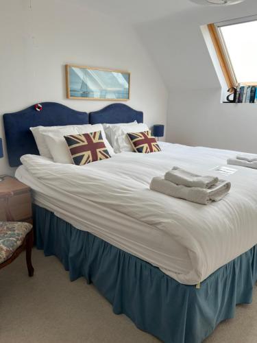 a large white bed with a blue head board at Highfields Farm B&B in Stone