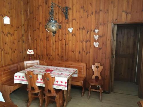 comedor de madera con mesa y sillas en Grazioso appartamento, en Cassina Valsassina