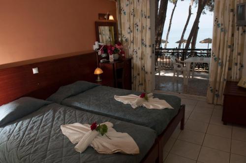 a hotel room with two beds with towels on them at Castello Beach Hotel in Argasi