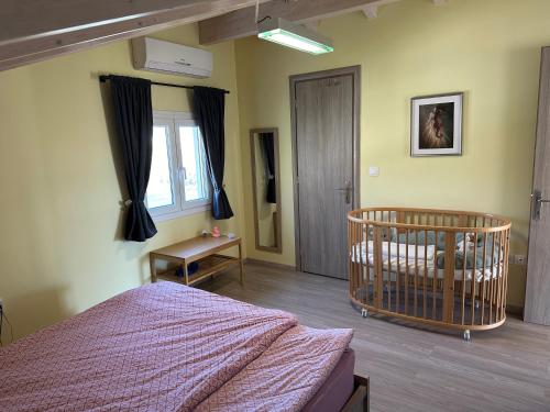 1 dormitorio con cuna en la esquina de una habitación en GS-Vibes, en Porto Rafti
