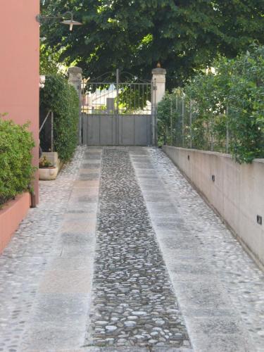 a stone walkway with a fence and a gate at La Residence da Caterina in Vittorio Veneto