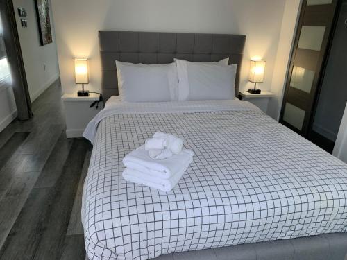 ein Schlafzimmer mit einem Bett mit Handtüchern und zwei Lampen in der Unterkunft Parc de l'Île Melville 1 - Maison flottante in Shawinigan