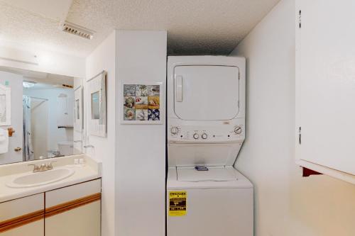 a small white bathroom with a washer and dryer at Lei Lani Village 103 in Orange Beach