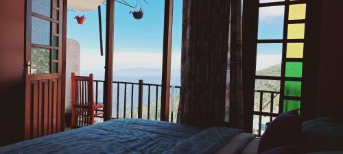 a bedroom with a bed and a view of a balcony at Il Villino haputale in Haputale