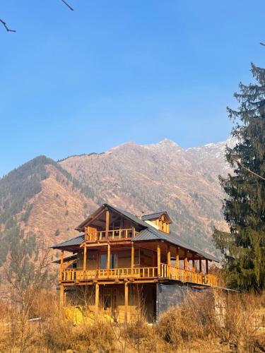 ein großes Holzhaus mit Bergen im Hintergrund in der Unterkunft Woodstock Villa Tulga in Kalgha