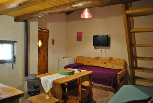 ein Schlafzimmer mit einem Bett, einem Tisch und einem Fernseher in der Unterkunft ALTOS DE PUNILLA in Casa Grande