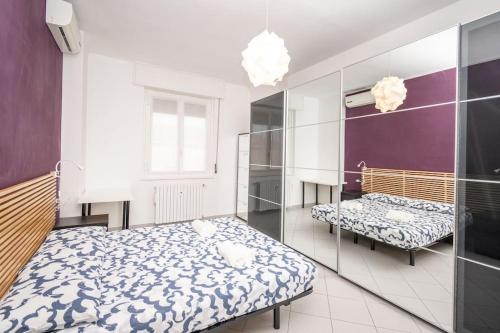 - une chambre avec 2 lits et un miroir dans l'établissement Grazioso appartamento in Bicocca con AC e Wi-fi, à Milan