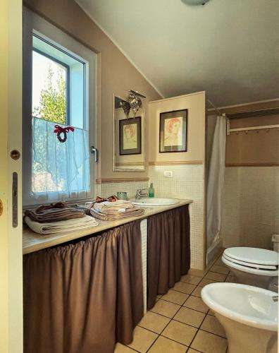 a bathroom with a sink and a toilet and a window at Un Giardino sul Lago in Montefiascone