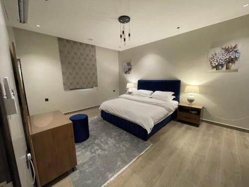 a bedroom with a bed with a blue head board at شقة عائلية خاصة in Dhahran