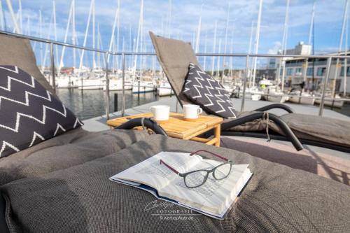 une table avec un livre et des verres sur un bateau dans l'établissement Hausboot Seepferdchen, à Heiligenhafen