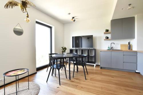 a kitchen and dining room with a table and chairs at Amazing High-Rise 1BR with 11th Floor Views in Tallinn