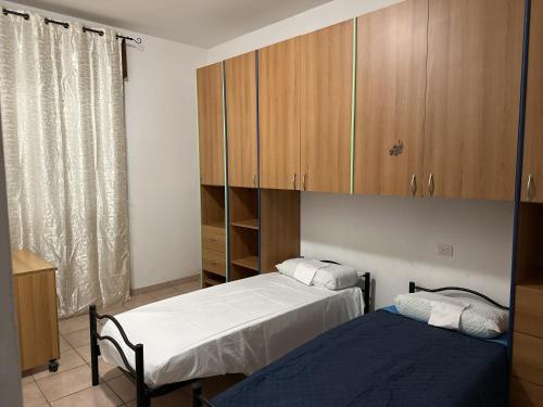 a bedroom with two beds and a cabinet at Olbia via modena in Olbia