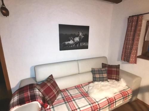 a living room with a couch and a picture of deer at Landhaus Schusterfranz in Oberneudorf